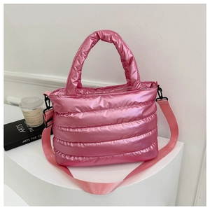 Detailed macro view of pink puffer bucket bag with quilted fabric and woven strap