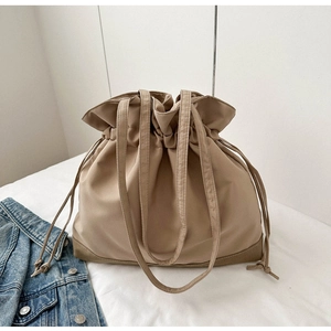 Detail of khaki drawstring tote bag featuring subtle stitching and smooth nylon texture