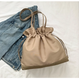 Close-up of khaki drawstring tote bag with refined stitching on soft fabric