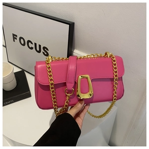 Detailed close-up of glossy magenta crossbody bag with gold chain and unique metal buckle