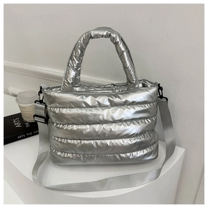 Detail of silver quilted bucket bag with adjustable wide strap and metallic finish