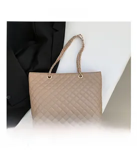 Detailed close-up of beige quilted leather tote bag with elegant gold chain shoulder straps