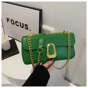 Close-up of bright green leather crossbody bag with gold chain and unique metal clasp