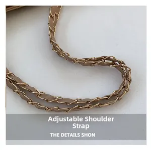 Detail of adjustable shoulder strap featuring woven gold chain and light brown leather