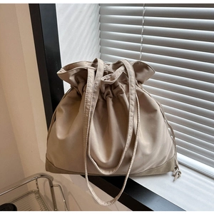Detail of khaki drawstring tote bag with reinforced bottom base and thin shoulder straps