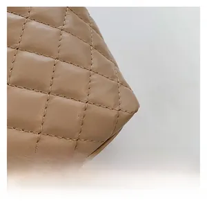 Detailed close-up of quilted diamond pattern and stitching on khaki tote bag