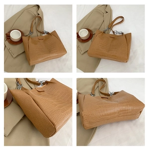 Detailansicht der kamelfarbenen Krokodilleder-Tasche mit Silberkette und großem Volumen