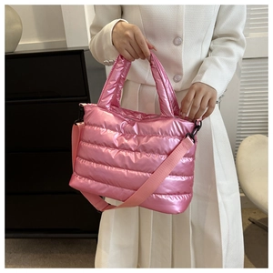 Detail of pink metallic quilted puffer tote bag showing glossy texture and shoulder strap