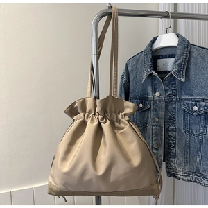 Detail of beige drawstring oxford tote bag showing soft fabric texture and reinforced base