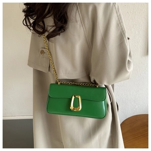 Detail of emerald green leather shoulder bag featuring a wide gold metal D-ring buckle