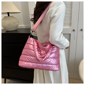 Detailed close-up of pink metallic quilted bucket bag with wide fabric shoulder strap
