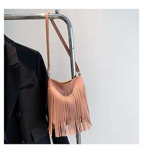 Close-up of pink lychee leather hobo bag featuring stylish long tassel details