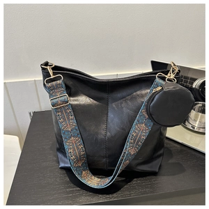 Detail of black PU tote with colorful ethnic woven strap and small round coin purse