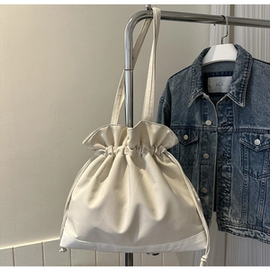 Minimalist off-white drawstring canvas tote bag with contrast stitching and cloud-edge design