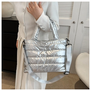 Silver quilted tote bag detail with adjustable strap and metallic puffer texture