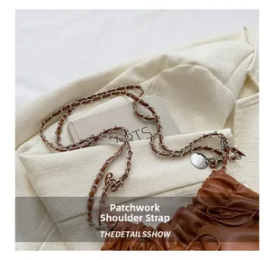 Detail of premium brown pleated bucket bag showing the metal chain and leather strap