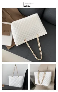 Detail of white quilted tote bag featuring golden metal chain and woven leather straps