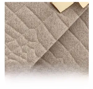 Macro shot of stone texture felt fabric with premium gold metal hardware detail