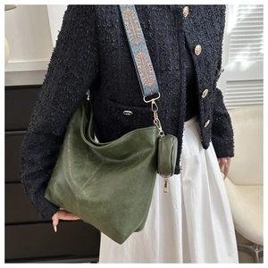 Detail of dark green hobo tote bag featuring a bohemian embroidered wide strap and coin purse
