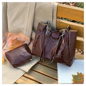 Detailansicht der braunen Kroko-Tasche mit Kettenriemen in herbstlicher Szene
