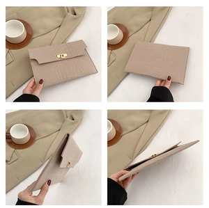 Detail view of beige crocodile embossed envelope clutch bag with gold twist lock buckle