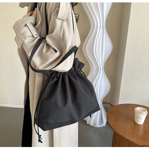 Detail of black drawstring shoulder bag made of high-quality nylon with precise stitching
