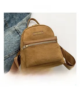 Detail view of brown matte texture small backpack with front zipper and FASHION leather label