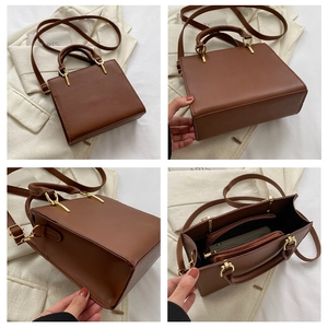 Detail view of brown leather handbag showing interior compartments and golden hardware