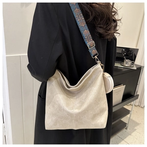 Detail of beige faux leather tote with ethnic print shoulder strap and coin purse