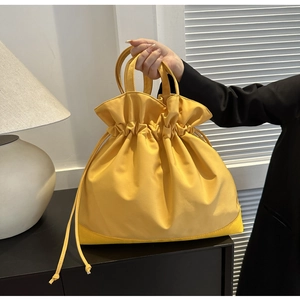 Detail view of large mustard yellow tote bag with drawstring closure and fabric texture
