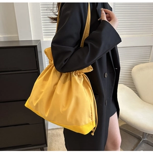 Detail of yellow nylon drawstring bucket bag showing high-density fabric and reinforced stitching