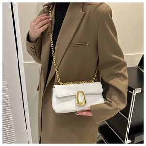 Detail of white leather crossbody bag with golden geometric clasp and chain strap