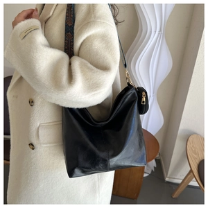 Black matte leather tote with ethnic woven strap and detachable coin purse on model