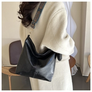 Minimalist black tote bag with vintage ethnic print wide strap shown on shoulder