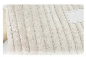 Macro view of beige corduroy fabric texture with minimalist white label detailing