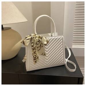 Sac à main blanc matelassé avec foulard en soie jaune au manche et bandoulière fine