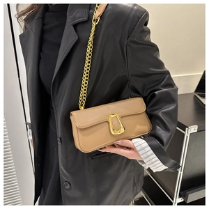Chic khaki shoulder bag with gold horseshoe buckle and chunky chain strap on model