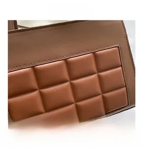 Close-up of brown quilted faux leather material with elegant square stitching detail