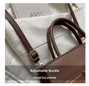 Detail showing the adjustable metal buckle and stitching on the brown leather strap