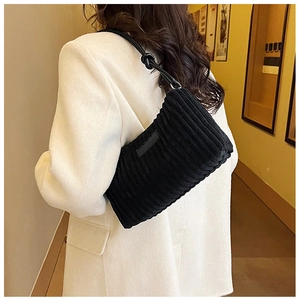 Chic black corduroy shoulder bag with leather straps on model in white wool coat