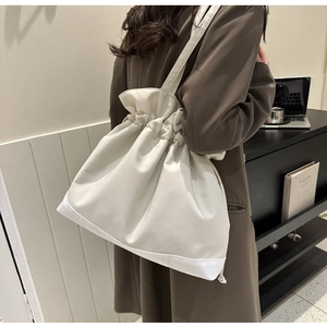 Detail of off-white large capacity oxford bucket bag with pleated drawstring closure and stitching