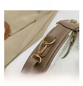 Dettaglio borsa in pelle intrecciata con moschettoni dorati e cuciture a contrasto