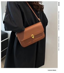 Détail du sac à bandoulière en cuir caramel avec un fermoir rotatif métallique doré