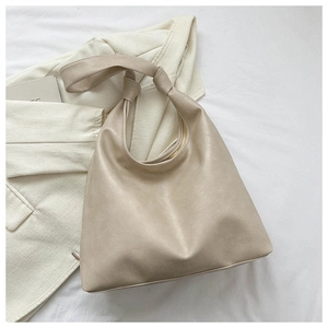 Hobo shoulder bag in beige PU leather with stylish knotted strap detail on textured fabric