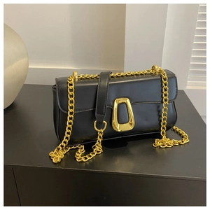 Minimalist black leather shoulder bag with bold gold geometric buckle and chain strap