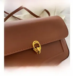 Détails du sac bandoulière en similicuir marron avec coutures et boucle dorée à double anneau