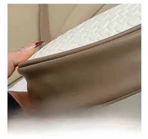 Dettaglio in pelle bianca intrecciata e pelle liscia marrone con cuciture precise sulla borsa