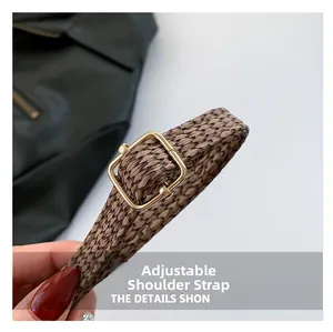 Close-up of adjustable brown woven shoulder strap with gold metal buckle for handbag