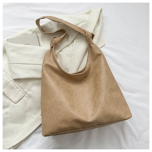 Detail of khaki PU leather shoulder bag featuring unique knotted strap design and soft texture