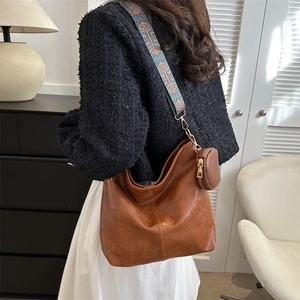 Vintage brown leather shoulder bag with colorful jacquard strap and mini coin purse charm